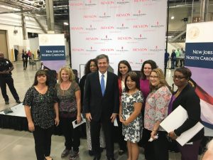 Governor Roy Cooper stands with Revlon employees.