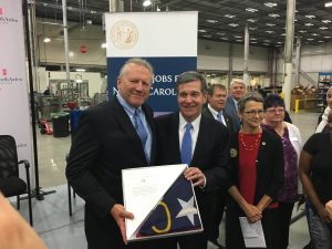 Governor Roy Cooper stands with Revlon Senior Vice President of Manufacturing (America's), Bill Welz.